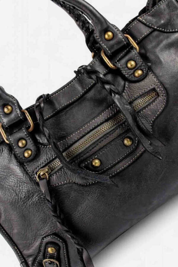 Bolso city motero inspiración vista de cerca detalle de tachas y cordones de piel trenzada