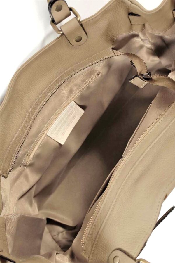 vista interior del bolso shopper de piel con detalle del forro de tela y bolsillo interior con cremallera