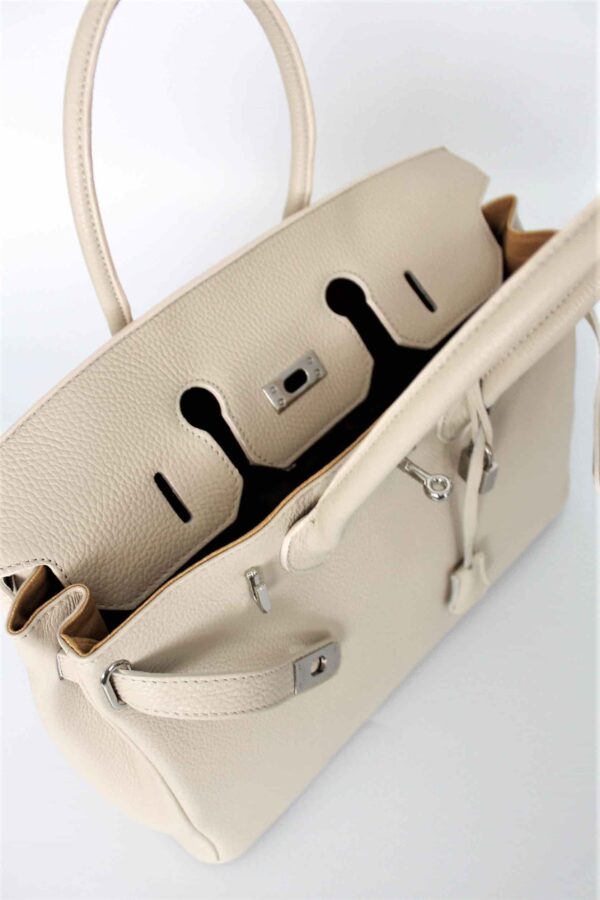 detalle del interior y el forro de piel porcina de los bolsos icónicos con candado color beige