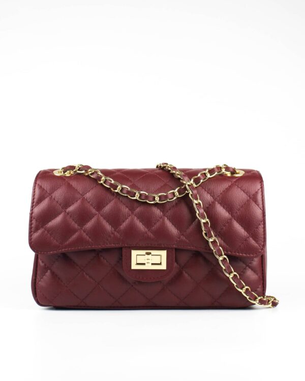 bolso acolchado clásico burdeos con asa de cadena dorada. Vista frontal con detalle del asa. El bolso clásico más famoso de la historia