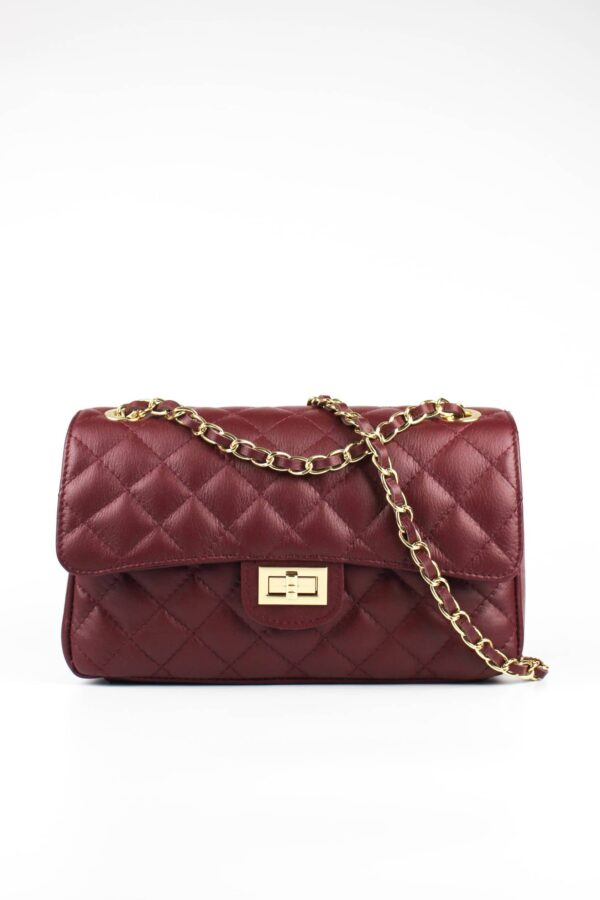 bolso acolchado clásico burdeos con asa de cadena dorada. Vista frontal con detalle del asa. El bolso clásico más famoso de la historia
