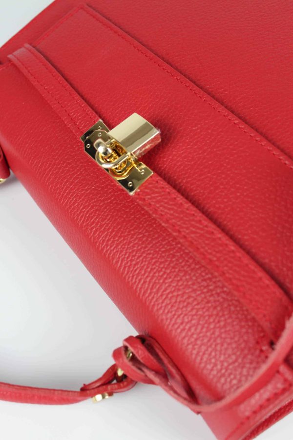 bolso de piel estructurado con candado rojo vista detallada del cierre con tiras de piel y candado