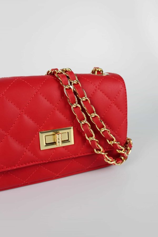 vista lateral con detalle del asa de cadena dorada entrelaza en piel al tono del bolso clásico de piel acolchada rojo