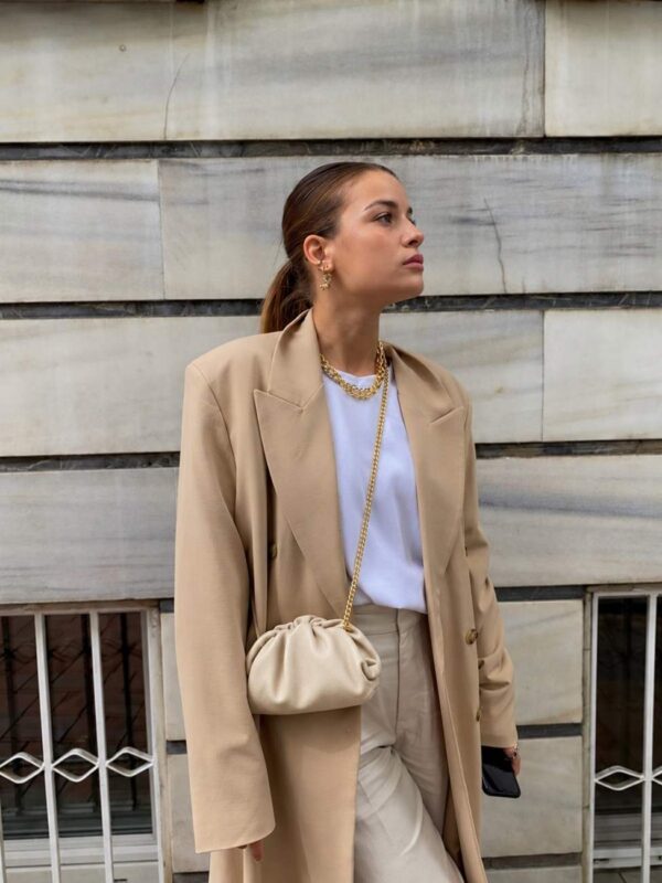 Modelo portando el Bolso fruncido piel beige con un look moderno de tonos neutros