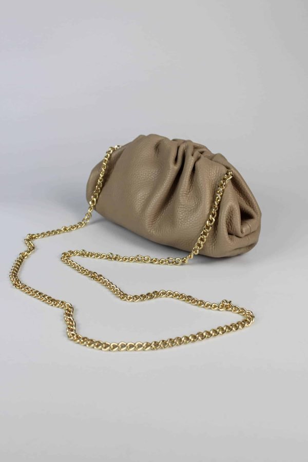 Bolso inspiración con frunces vista lateral con el asa larga de cadena dorada