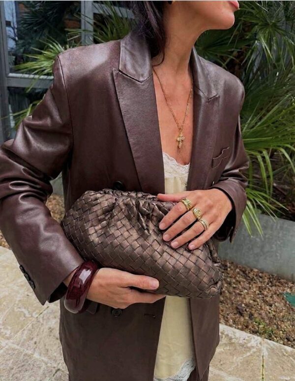 modelo portando el bolso de inspiración pouch trenzado marrón con un look urbano y elegante