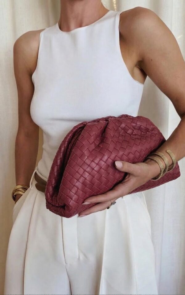 bolso fruncido piel trenzada con modelo portando el bolso en la mano con un look urbano