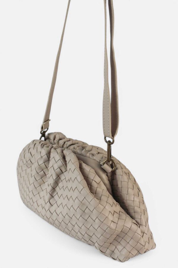 vista del bolso pouch piel trenzada de inspiración den piel trenzada beige suspendido en el aire con su asa larga extraíble de piel