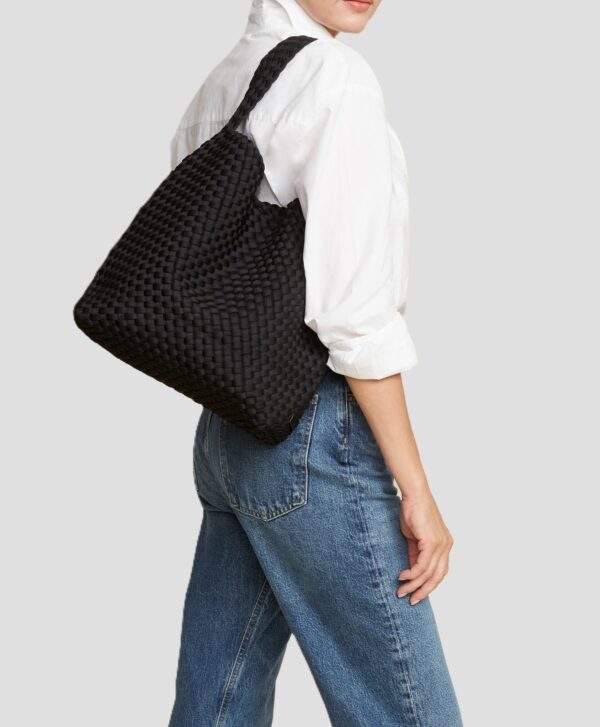 bolsos neopreno trenzados vista con modelo portando el bolso en el hombro con unos jeans y camisa blanca
