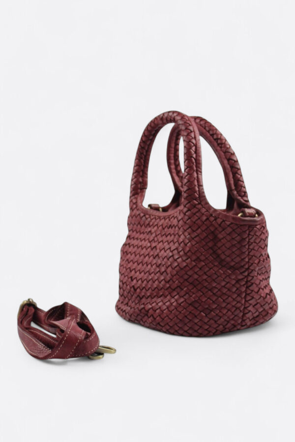 vista lateral del bolso trenzado rojo italiano fabricado artesanalmente con detalle del asa larga extraíble