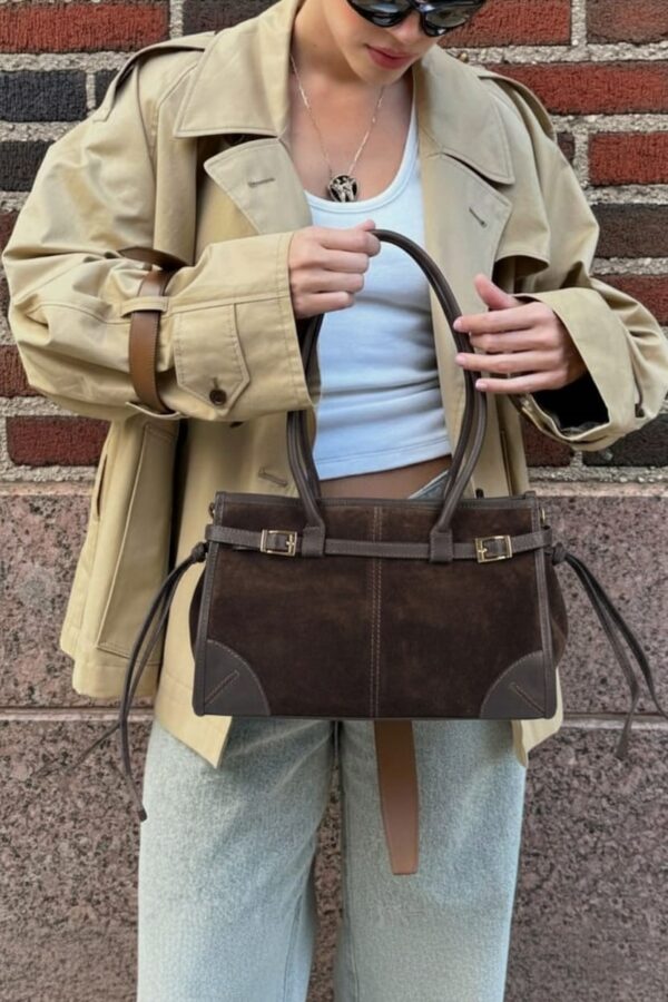 modelo llevando el bolso de inspiración Bonnie estructurado en ante marrón chocolate con un look urbano
