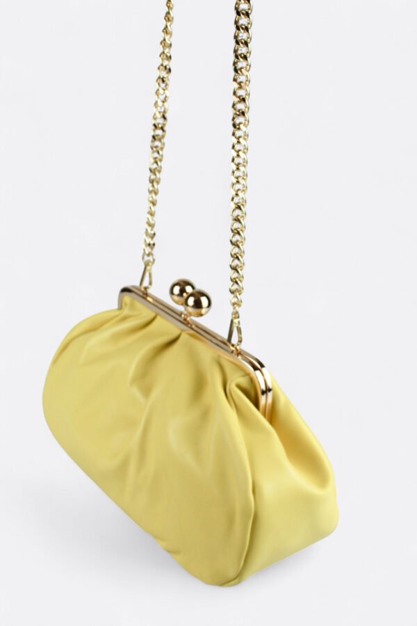 Bolso bombonera amarillo suave con su asa de cadena extraíble para llevar al hombro