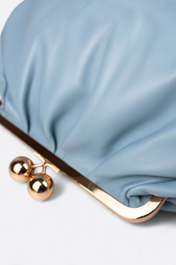 Detalle del cierre metálico de bolas retro en el clutch azul pastel