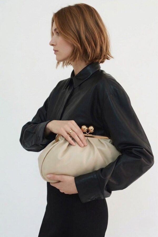 Mujer luciendo el bolso de mano vintage color beige con un look casual de fin de semana