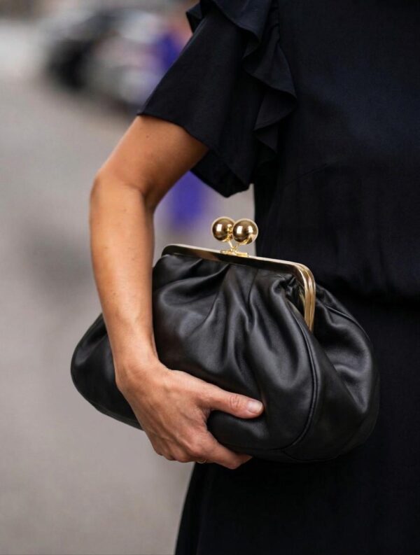 Mujer luciendo el maxi monedero de fin de semana color negro con un look urbano