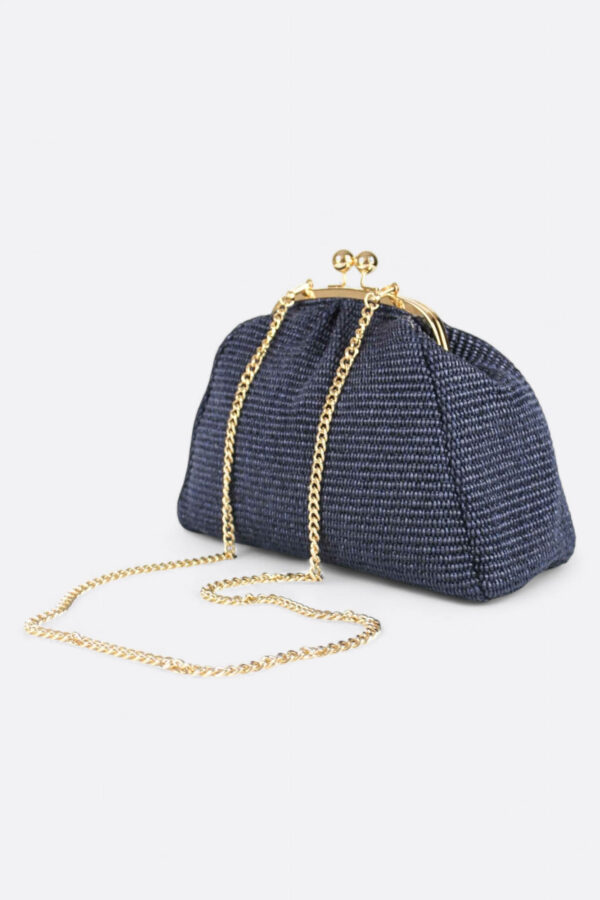 Bolso de rafia azul marino con asa fina de cadena dorada cruzada.