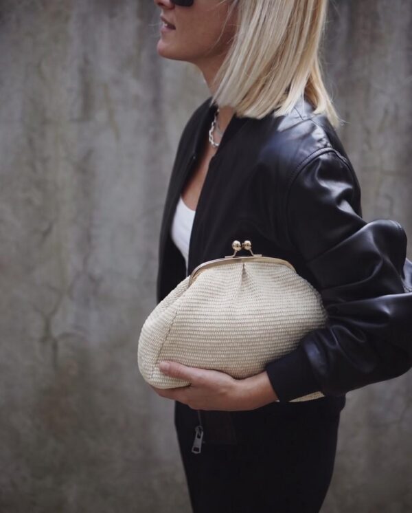 Modelo portando el Bolso de rafia natural beige claro con un look urbano blanco y negro