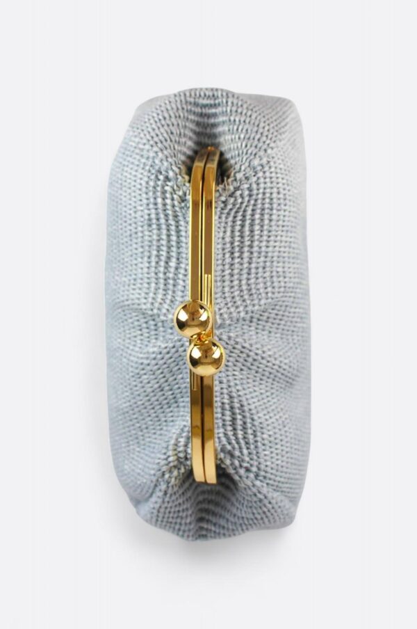 Vista superior del clutch de rafia azul pastel con sus llamativas esferas doradas.