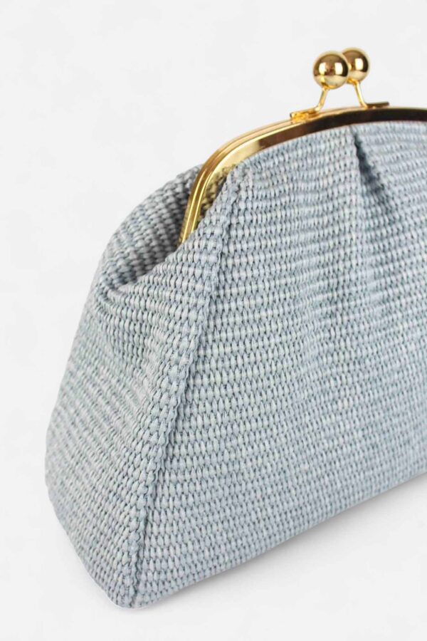 Detalle del marco dorado y el trenzado premium del bolso de rafia azul claro Monaur Carrie