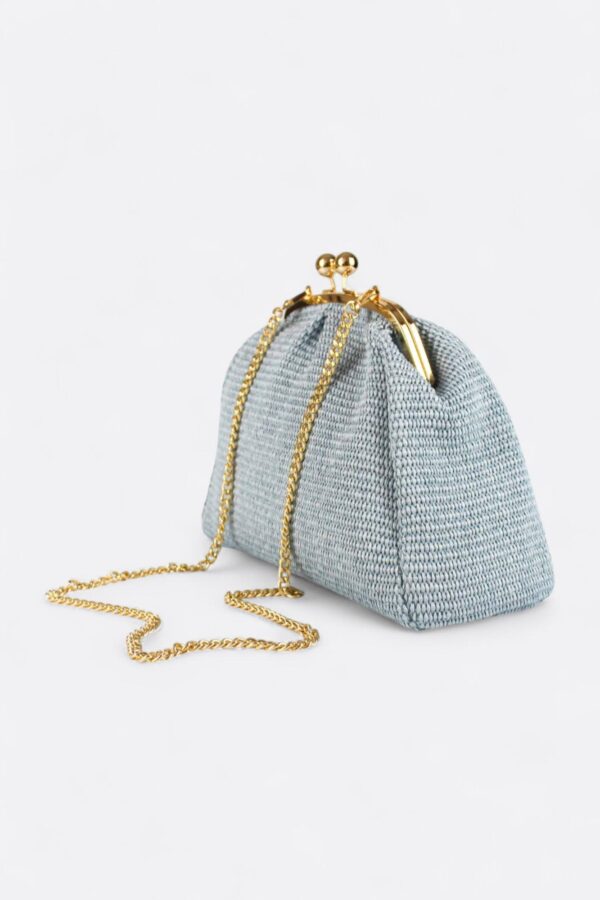 Bolso de rafia natural azul claro combinado con su asa fina de cadena dorada extraíble