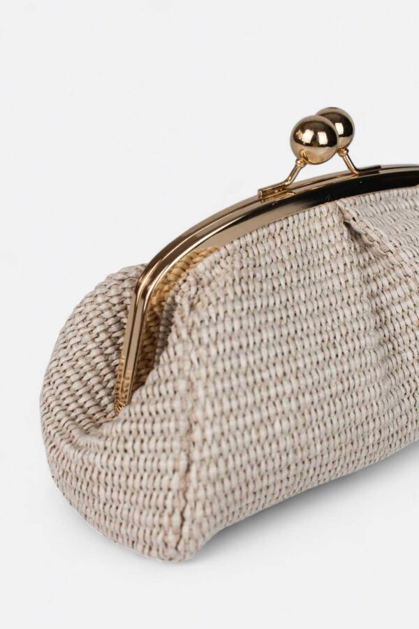 Detalle de la textura trenzada premium y la boquilla metálica del bolso pequeño de rafia.