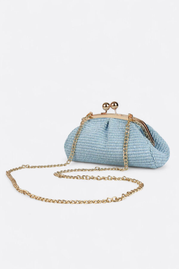 Clutch mini de rafia con cierre de bolas en color azul claro y su delicada asa de cadena dorada.