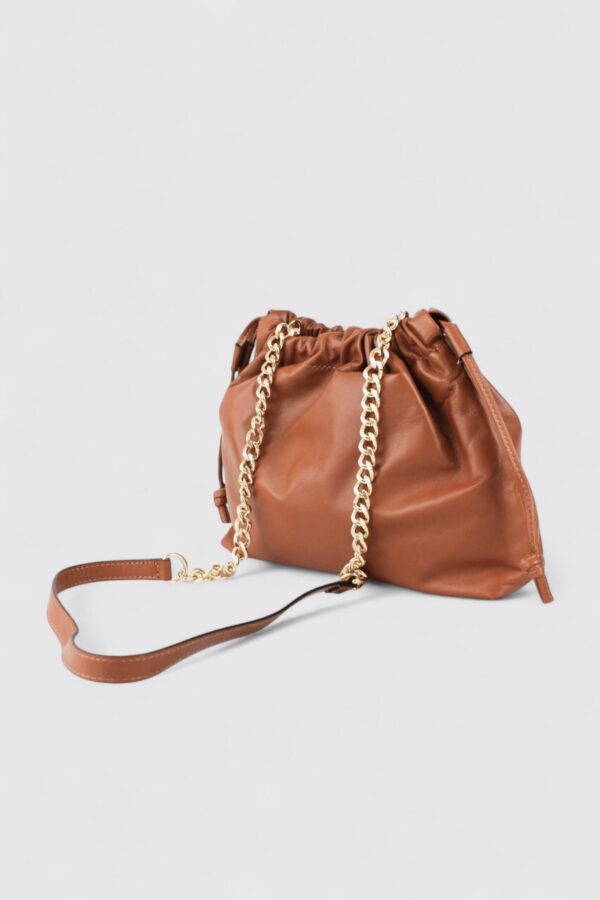 Bolso italiano en tono camel mostrando la correa de piel larga y la cadena dorada cruzada.