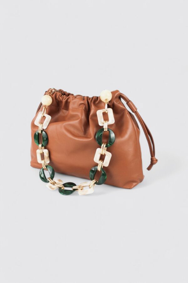 Bolso bombonera de piel camel con asa de mano formada por eslabones gruesos de resina verde.