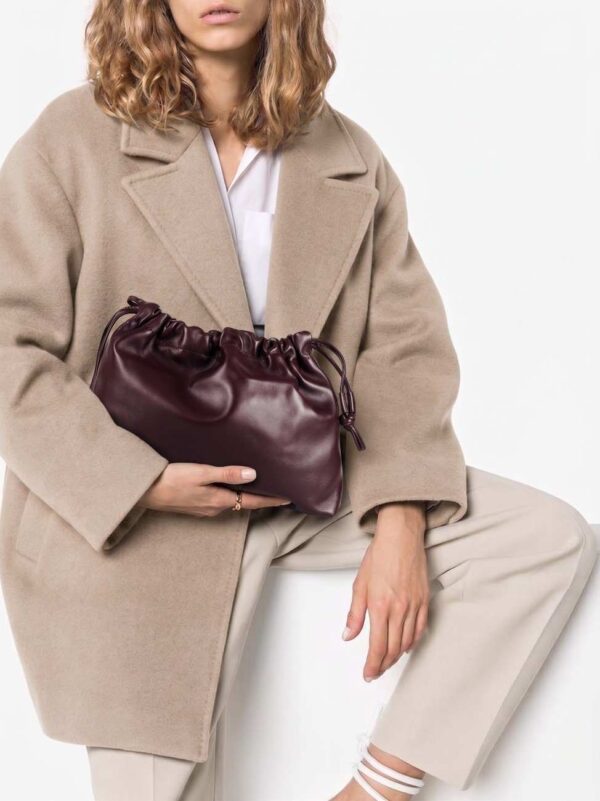 Modelo llevando el bolso de piel fruncido marrón chocolate con un look de tendencia arreglado
